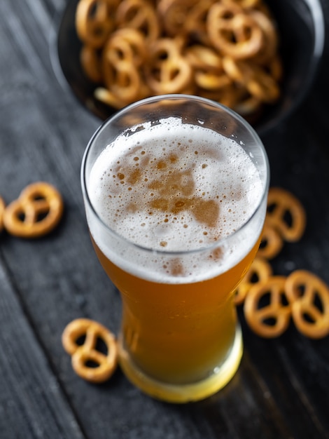 Un verre de bière de blé et un apéritif de bretzel traditionnel sur la table