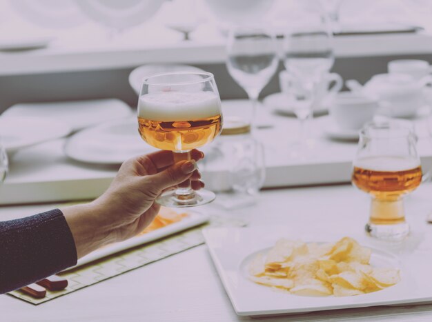 Verre de bière blonde dans les mains