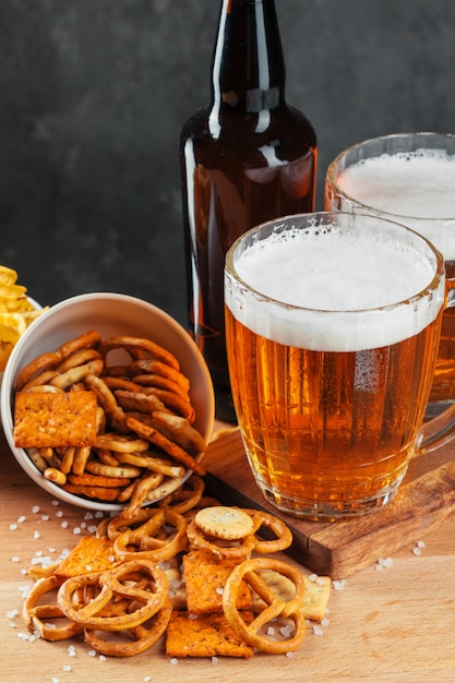 Verre à bière avec bretzel et collations de saucisses séchées