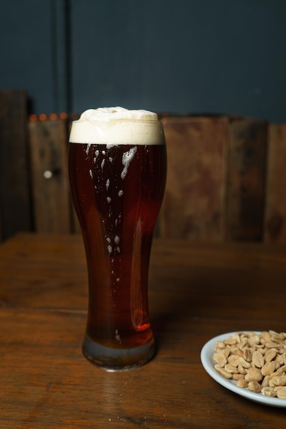 Verre à bière et cacahuètes sur une table