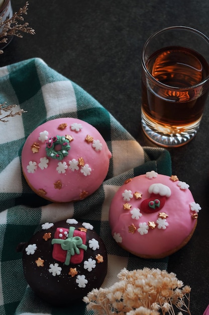 Un verre de bière est assis à côté d'un beignet avec un tissu à carreaux vert et blanc.