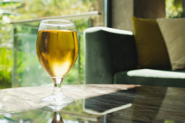 Verre de bière filtrée légère sur la table devant le canapé