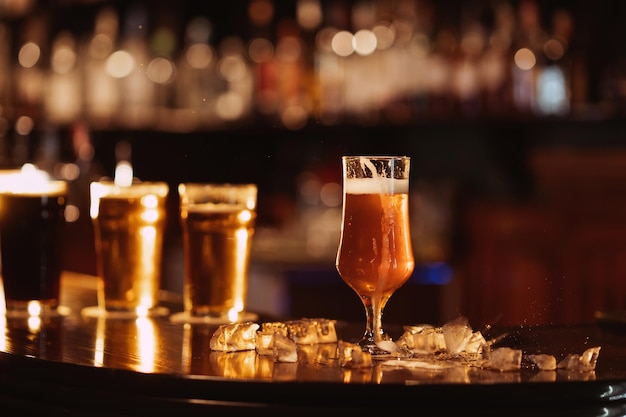 Verre de bière en mousse dorée non filtrée avec sur le comptoir du bar