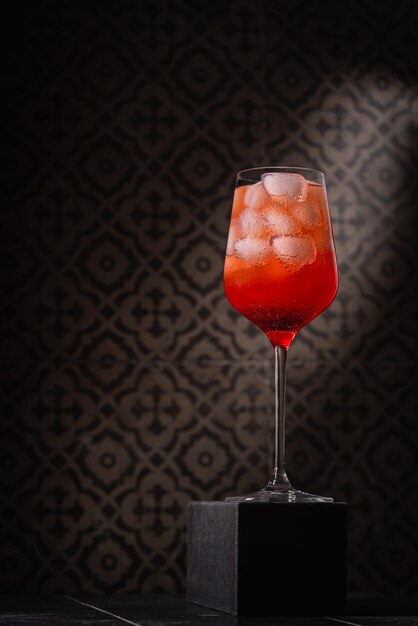 Photo verre de boisson alcoolisée avec un cocktail rouge glacé aperol spritz dans le verre sur fond sombre