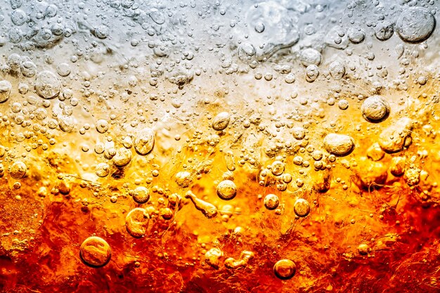 Photo verre de boisson gazeuse avec éclaboussures de glace sur fond sombre verre de cola dans le concept de fête de célébration