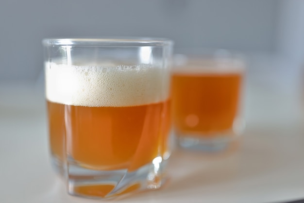 Verre avec une boisson à l'orange et de la mousse