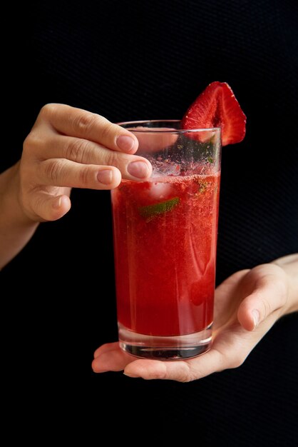 Verre à boisson rouge. Faites cuire à la maison un cocktail d'été frais avec des fraises, du citron vert et de la menthe. une boisson au smoothie pour le petit déjeuner sain et bonjour à base de super aliments, fruits, baies