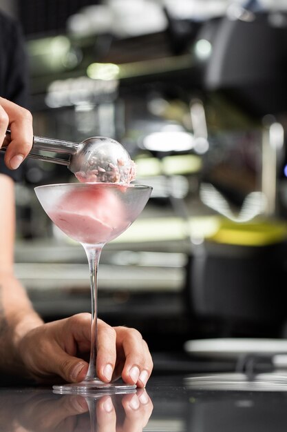 Photo verre de boules de crème glacée, vue de dessus avec espace de copie. barmen pouring scoop of berries ice cream sur fond gris