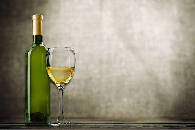 Verre et bouteille de vin blanc sur fond