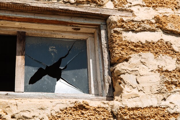 Verre brisé dans la fenêtre d'un immeuble. Problèmes de logement.