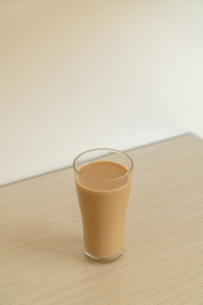 verre à café au lait avec des bouteilles de café prêtes à boire sur la table