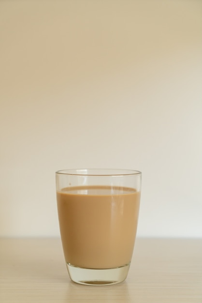 verre à café au lait avec des bouteilles de café prêtes à boire sur la table