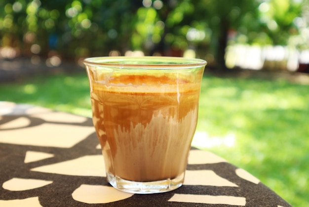 Verre de café au lait sale servi sur table de jardin