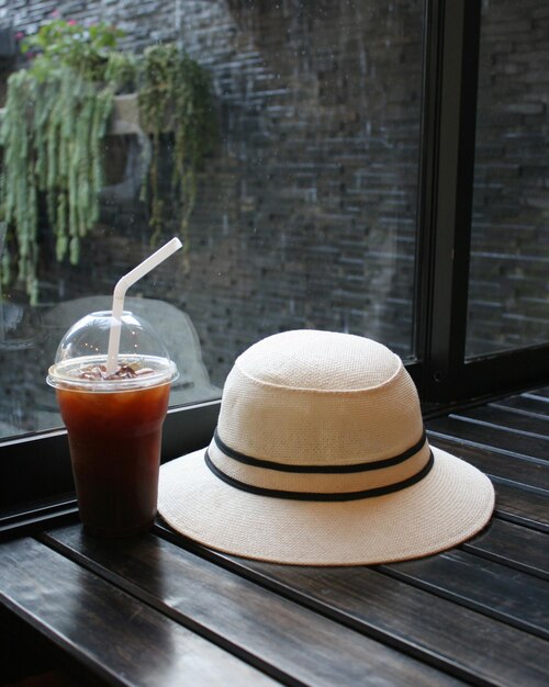 un verre de café et un chapeau de paille