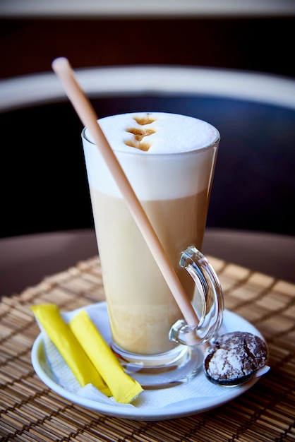 Un verre de café dans un verre avec des biscuits.