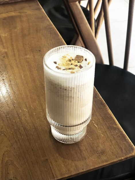 Photo un verre de café avec du lait surmonté de biscuits royaux en mode portrait