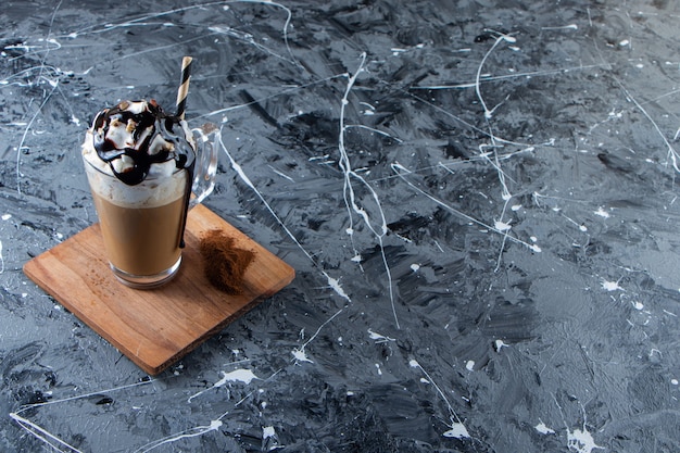 Verre De Café Froid Mousseux Avec Crème Fouettée Et Chocolat Sur Plaque De Bois. Photo Premium