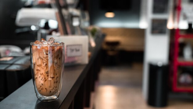 un verre de café glacé avec du lait sur la table