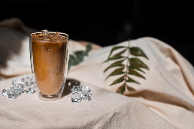 Un verre de café glacé avec du lait sur la table.