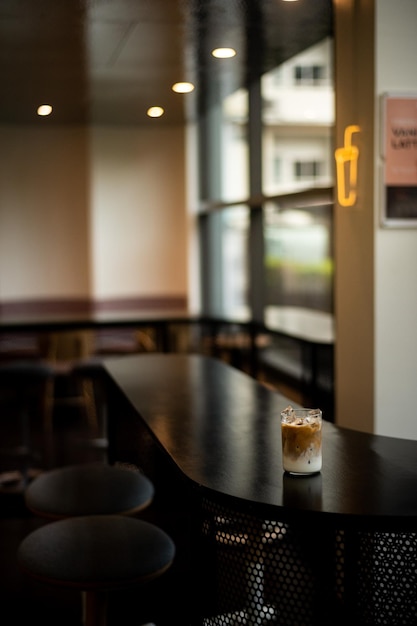 Un verre de café glacé est posé sur un comptoir dans un bar.