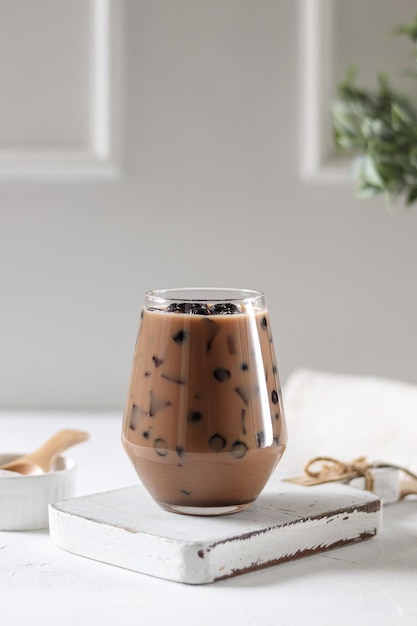 Un verre de café glacé est posé sur un livre posé sur une table.