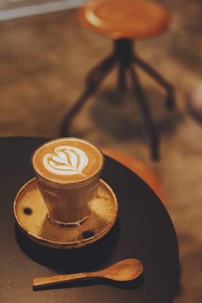 Un verre de café latte art sur table.