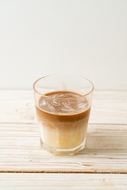 Verre à café sale, lait froid garni d'un café expresso chaud