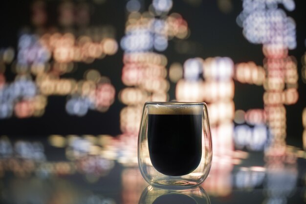 Verre de café sur la ville de nuit