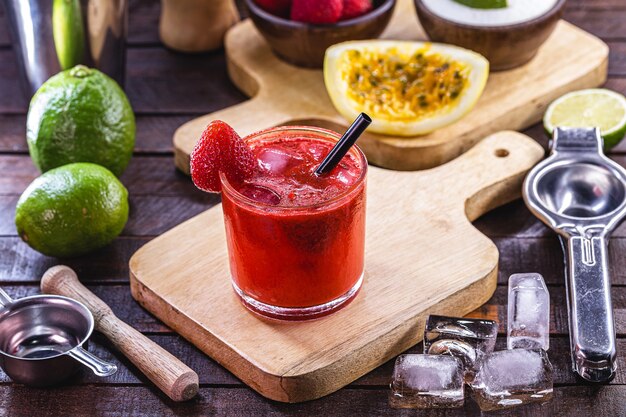 Verre de caipirinha, boisson typique du Brésil, à base de fraise, sur fond de bois rustique