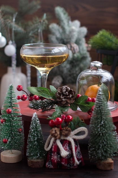 Un verre de champagne et de mandarines sur la table de Noël et du Nouvel An décoré d'arbres de Noël