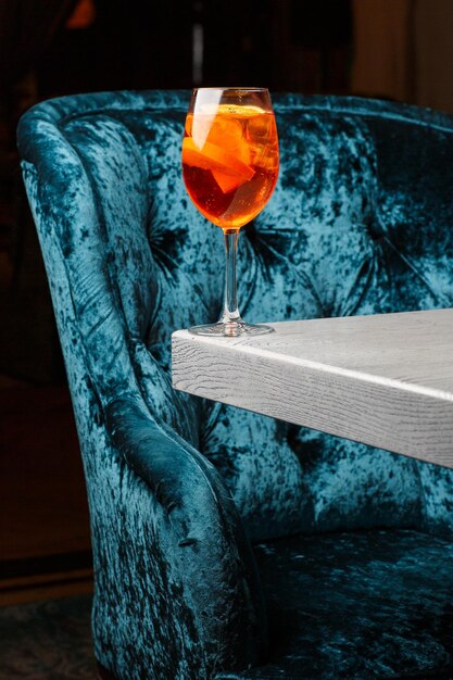 Photo verre de cocktail aperol spritz glacé servi dans un verre à vin décoré de tranches d'orange placées sur un fond noir