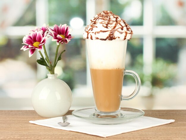 Verre de cocktail de café frais et vase avec fleur sur table en bois agrandi