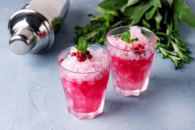 Verre de cocktail avec canneberge vodka menthe fond bleu vertical des boissons d'été froid