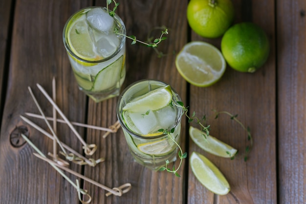 Verre de cocktail de concombre ou mocktail, boisson d'été rafraîchissante avec de la glace pilée et de l'eau gazeuse sur une surface en bois