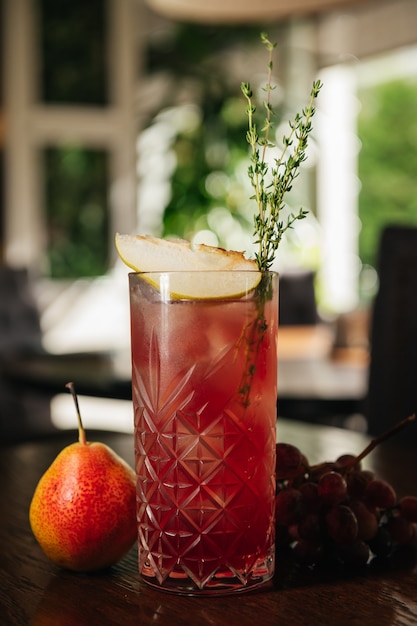 Verre à cocktail de limonade à la poire et au raisin. Boisson rafraîchissante froide ou boisson avec de la glace sur la table au restaurant