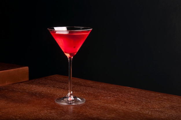 Verre à cocktail Martini avec cerise sur table en bois avec coin de vue de face de fond sombre