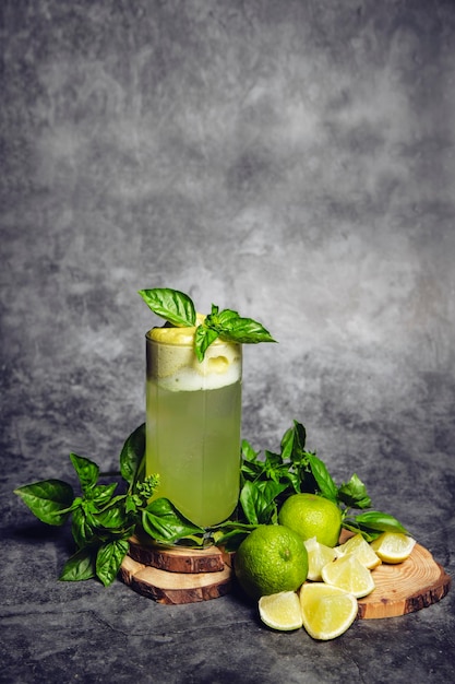 Verre à cocktail à la menthe et aux citrons verts sur fond gris avec espace de copie