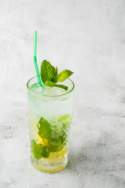 Verre avec cocktail mojito classique au citron et à la menthe, boisson rafraîchissante froide ou boisson avec de la glace sur fond de marbre brillant. Vue aérienne, espace copie. Publicité pour le menu du café. Photo verticale.