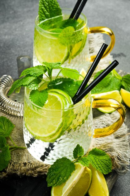 Photo un verre de cocktail de mojito traditionnel avec de la menthe et du citron sur une table de pierre sombre