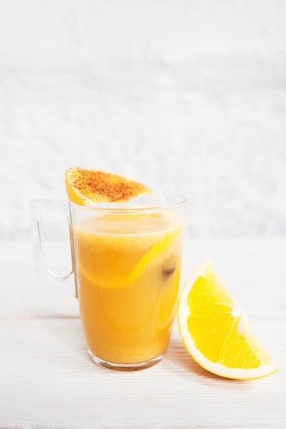 Verre à cocktail avec punch orange rafraîchissant sur blanc