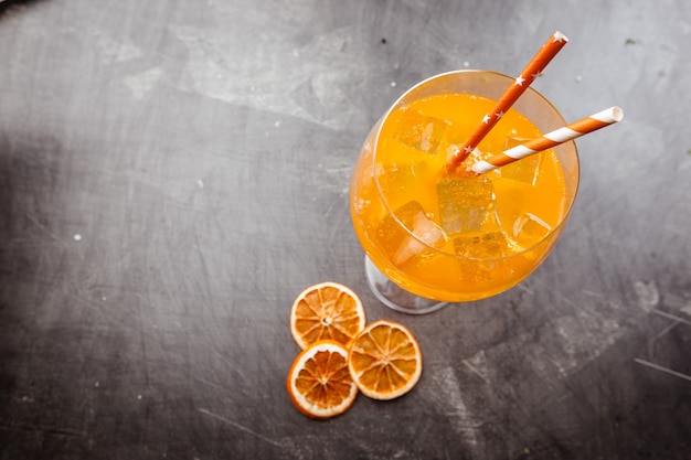 Verre de cocktail soda aperol avec des glaçons sur noir