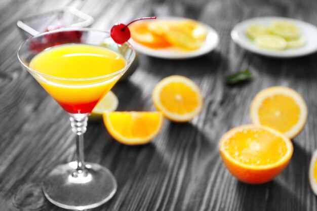 Verre de cocktail Tequila Sunrise avec des tranches d'orange sur table en bois