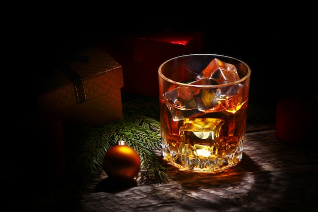 Verre avec cognac ou whisky, boules de Noël et bougies.