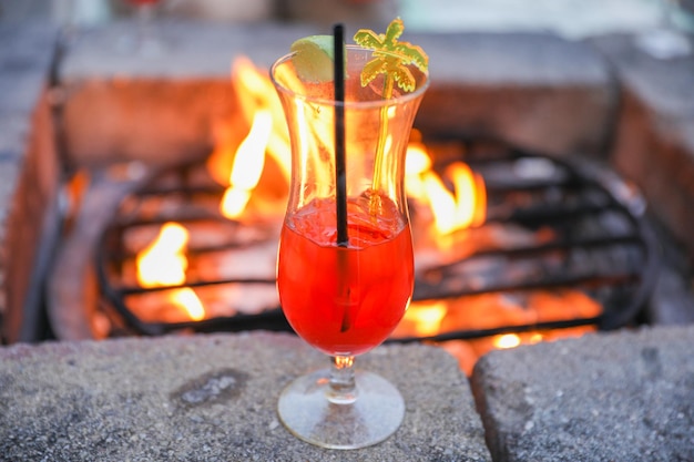 Un verre sur une corniche en pierre avec un feu en arrière-plan