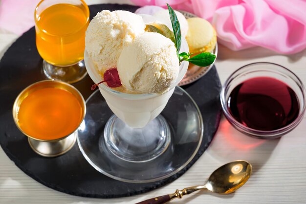 Un verre de crème glacée avec un chiffon rouge sur la table à côté.