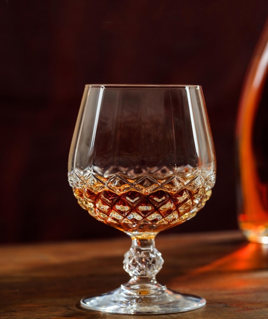 Un verre de cristal de cognac sur un comptoir en bois