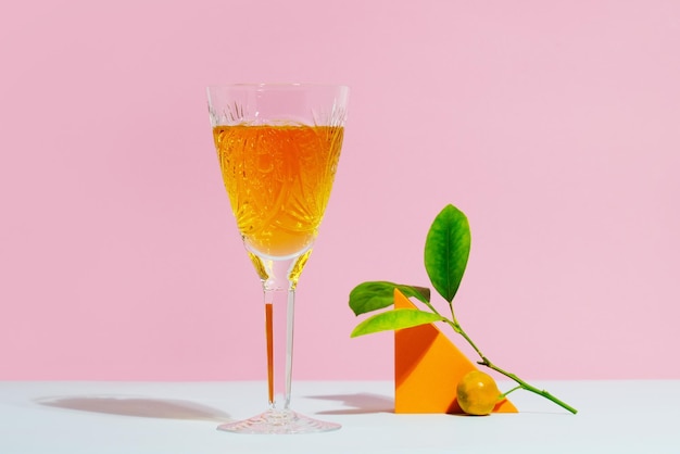 Verre en cristal de jus de mandarine sur fond coloré Concept de boisson d'été