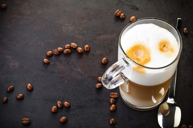 Verre de cuillère de café au lait sur rustique foncé