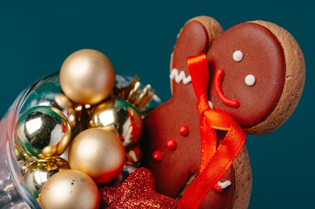 Verre avec décorations de Noël sur fond vert foncé