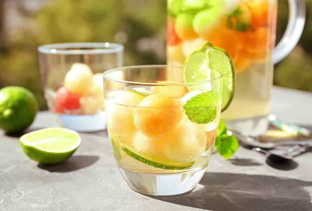Verre de délicieux cocktail avec des boules de melon sur table